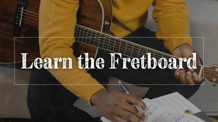 Guy playing guitar and making notes